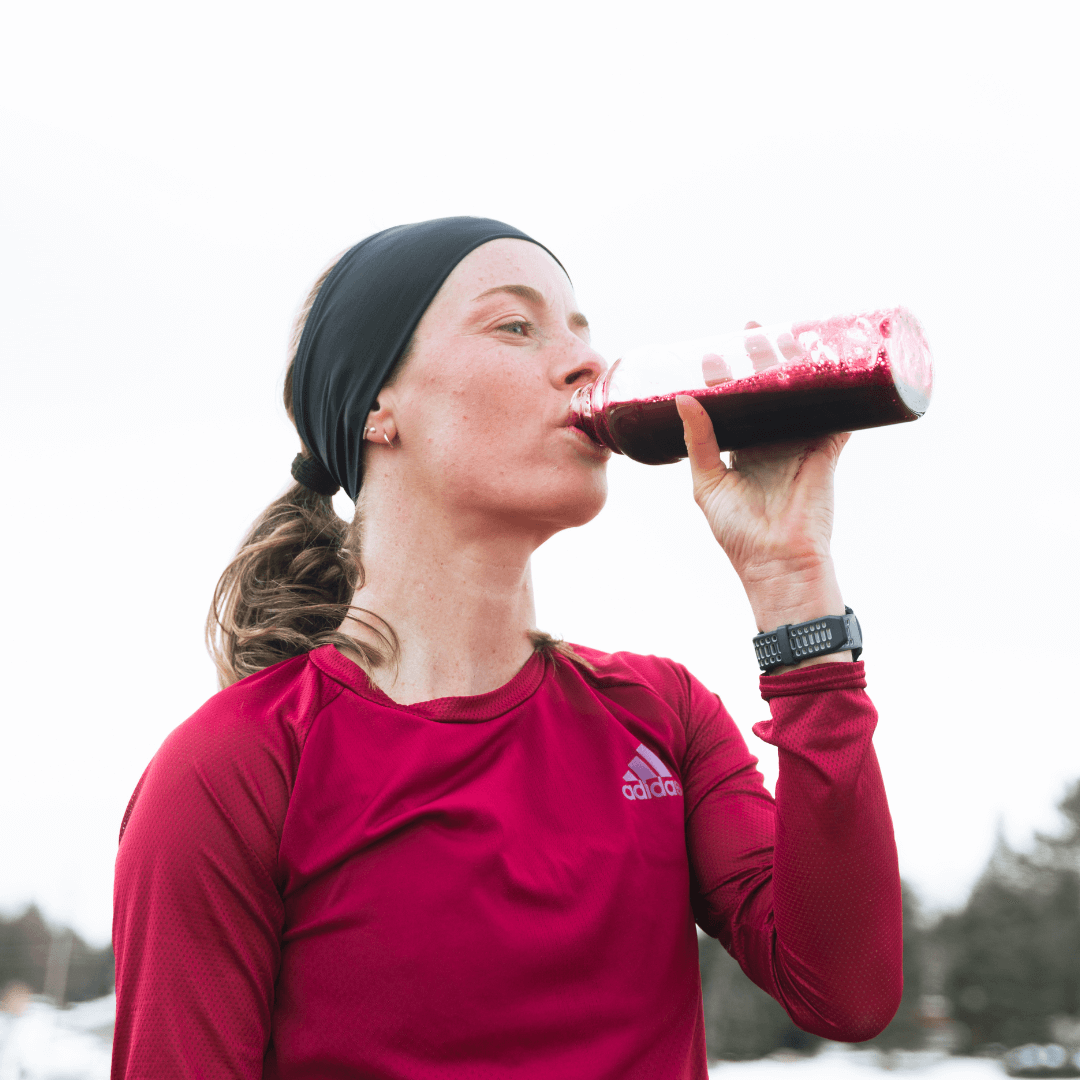 female runner drinking blackcurrant powder